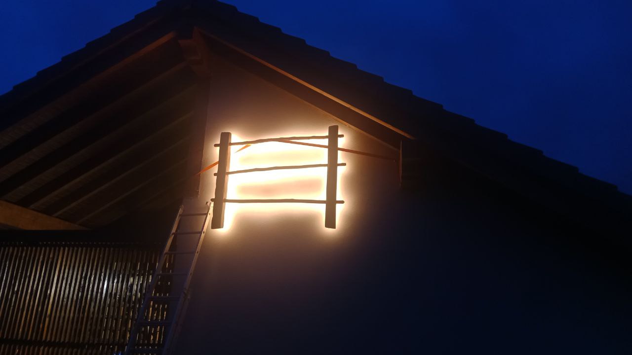 Rotulo organico iluminado en exterior de negocio por la noche fabricado por TOVARNA