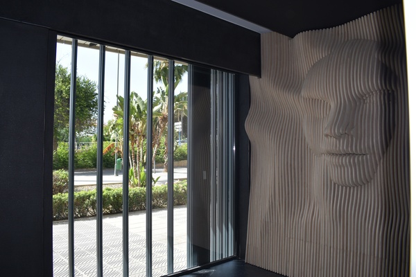 Detalle del mural de lamas de madera con rostro instalado en vivienda de lujo Benalmadena - TOVARNA